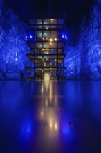 Illuminated structure in front of an intense blue forest projection in an interior, Amazonia