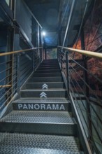Metal staircase with the inscription 'PANORAMA' leading up to a blue light zone, Amazonia
