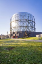 Round steel structure with green lawn underneath under blue sky, Amazonia exhibition, Gasometer,