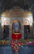 Artfully designed altar in a church, framed by colorful flowers and symbolic images, Sevanavank