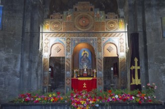 A richly decorated altar in a church surrounded by flowers and icons, Sevanavank Monastery,