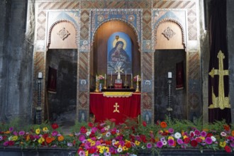 Magnificent altar in a church decorated with colorful flowers and religious paintings, Sevanavank