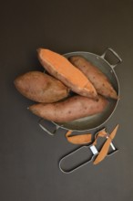 Sweet potatoes in skin with potato peeler, Ipomoea batatas