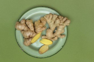 Ginger tubers and ginger slices on plate, Zingiber officinale