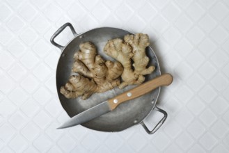 Ginger, ginger tubers in bowl with kitchen knife