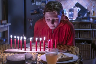 Young girl blowing out her thirteen burning birthday candles, Othenstorf, Mecklenburg-Western