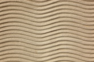 Beige sand with uniform wave patterns