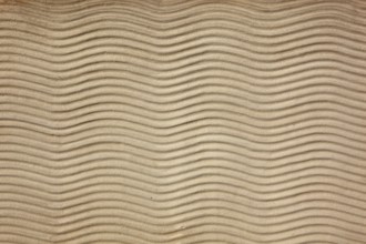Beige sand surface with uniform wavy lines
