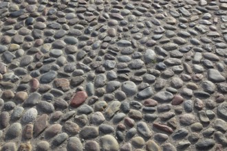 A floor of gray, round cobblestones with an uneven surface