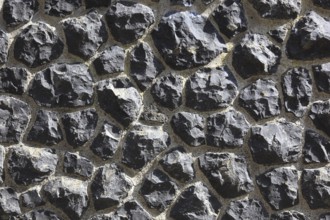 Rough wall of black rocks with distinctive structure