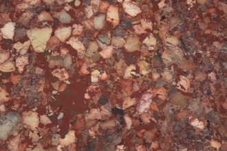 Red and brown marble with intense color variations and textured surface