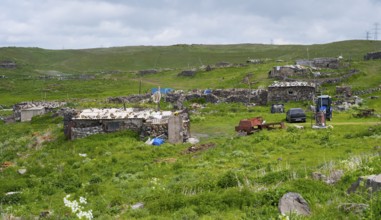 Rural town with dilapidated buildings and green fields under cloudy sky, small town on the M10 near
