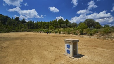 Open antique stadium with surrounding trees under a sunny sky, Ancient Stadium, Nemea, Peloponnese,