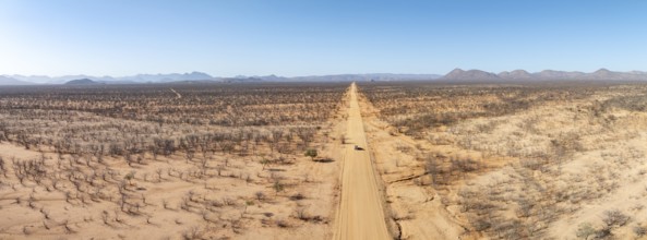 Travel, aerial view, car driving on road through arid landscape, Kunene region, Namibia