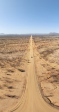 Travel, aerial view, car driving on road through arid landscape, Kunene region, Namibia