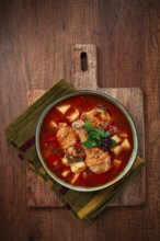 Souzi soup. Georgian dish, meat with oats, tomato sauce and herbs, on a wooden table