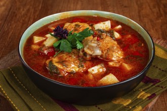Souzi soup. Georgian dish, meat with oats, tomato sauce and herbs, on a wooden table