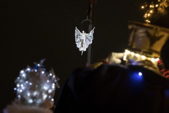 Two Black-winged Stilt walkers watch an artist hovering on a crane at the Christmas market