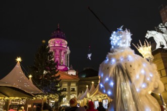 A Black-winged Stilt walker watches an artist hovering on a crane in front of the German Cathedral
