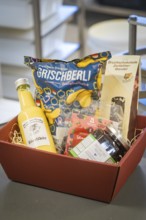 Red gift basket filled with delicacies such as eggnog and other specialities, Christmas baking,