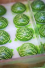 Green shaped chocolate balls with decorative pattern in a mold, Christmas baking, Haselstaller Hof,