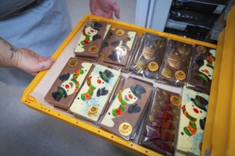 Colourful chocolate bars with snowman motifs in a gift box on the sales shelf, Christmas baking,