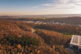 Road through autumnal forest with a wide view of landscape and buildings, MÃ¼hlacker, Enzkreis,