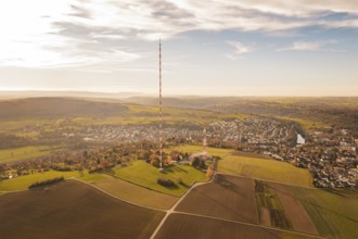 A radio tower stands in the middle of a vast, autumnal landscape next to a village, MÃ¼hlacker,