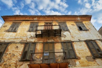 Old town of Nauplion, weathered faÃ§ade of an old building with balconies, under a clear sky,