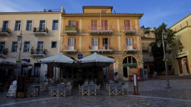 Old town of Nauplion, empty café area in front of historic faÃ§ade in sunny weather in a square,