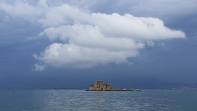 Bourtzi island fortress, small fortress on island under dramatically cloudy sky over the sea,