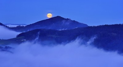View from the Gisliflue of the Jura foothills of Strihen, covered in fog, in the light of the full