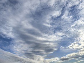 Cloud cover just in front of dusk with linear Altostratus clouds above it Cumulus mediocris with