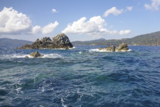Rock reef with three rocks rising out of the sea Water above water surface Sea level off the coast