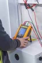 Technician uses measurement device to install solar system