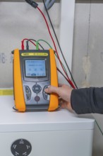 Person holding a measuring device device to check solar systems