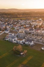 Village with modern buildings surrounded by fields in the evening light, Althengstett, Calw