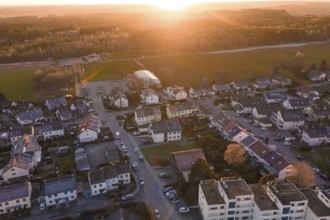 Suburb from the air with roads and cars in the evening sun, surrounded by nature, Althengstett,