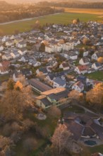 Residential area with many houses and trees seen from above in autumn sunlight, Althengstett, Calw