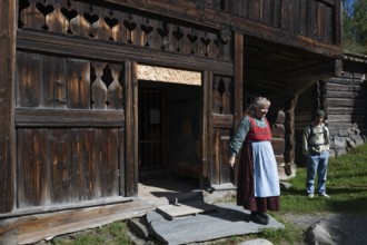 Tourist guide in traditional traditional costume and visitor, BjÃ¸rnstad, farm from VÃ¥gÃ¥,