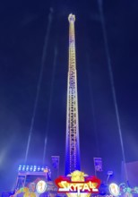 Colourfully illuminated Skyfal free fall tower at night at the All Saints Fair, Soest, North