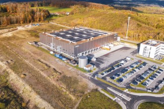 Building with a large parking lot in a hilly landscape, surrounded by autumn colors, new Lindenrain