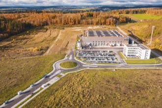 Industrial complex with roundabout, surrounded by forest and empty fields in an autumn environment,