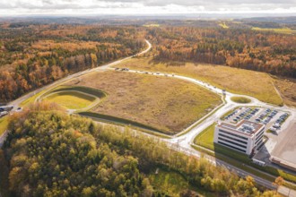 Industrial site with parking lot and adjacent forest in an autumn setting, new Lindenrain