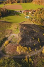Rural autumn landscape with farm and farmland surrounded by colorful trees and green fields, new