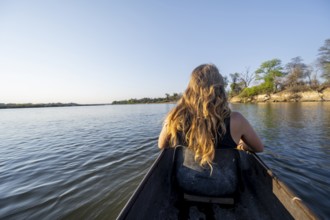 Tourists in a Mokoro, dugout boat on the Okavango River, Caprivi Strip, Namibia