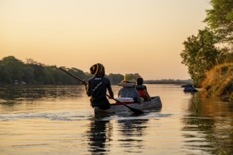 Sunset boat trip, tourists in a Mokoro, dugout boat on the Okavango River, Caprivi Strip, Namibia
