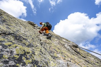 Mountaineers on steep rock face in the secured via ferrata Crocodile Mountain Lake at