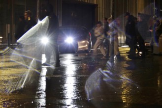 Passers-by in the evening in rainy weather in a city, November, Germany