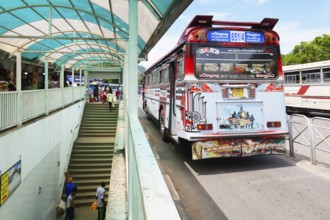Fully decorated buses passing near an underground passage, Kandy, Sri Lanka